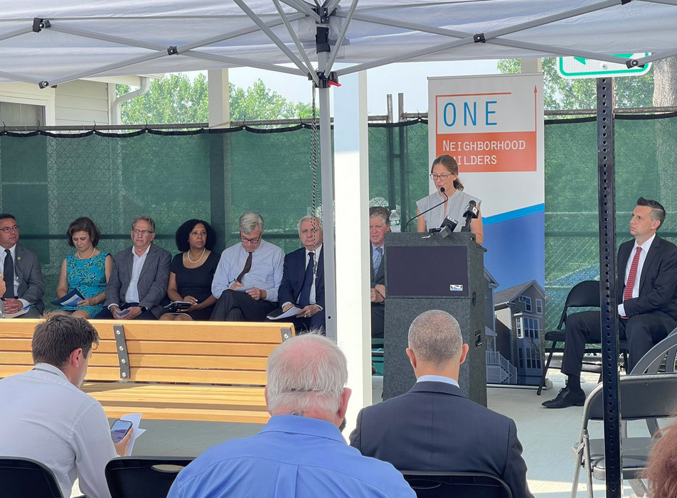 Jennifer Hawkins, executive director of ONE Neighborhood Builders, addresses the attendees at the celebration on July 26 of two affordable housing projects.